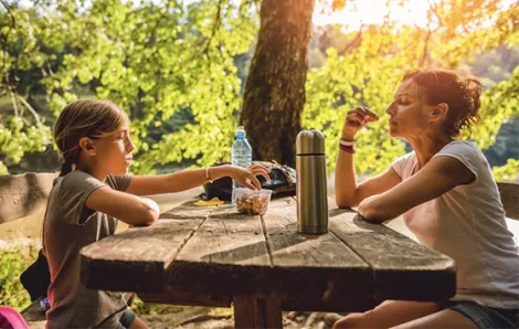 Parent and child eating while camping or hiking