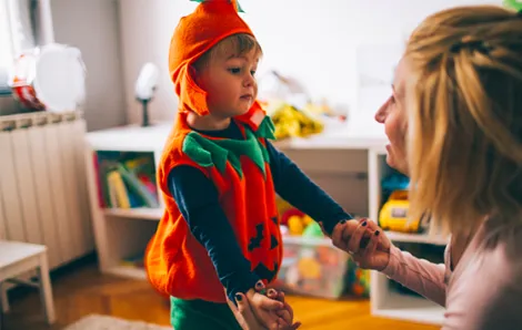 Little boy in Halloween costume with mom