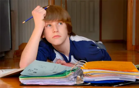 Upset teen boy doing homework