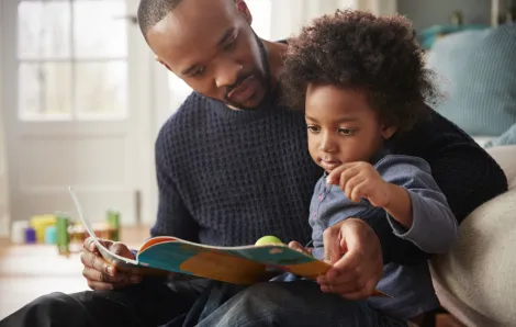 father and kid reading a picture book