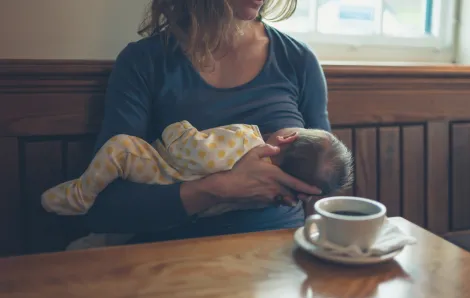 Mother breastfeeding her baby at a coffee shop