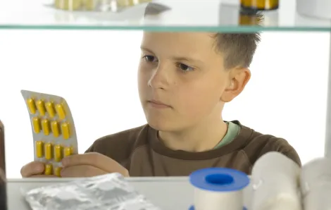 boy looking in medicine cabinet