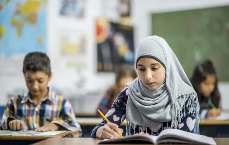 muslim girl writing at school