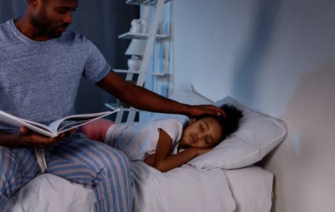 father reading to daughter at bedtime