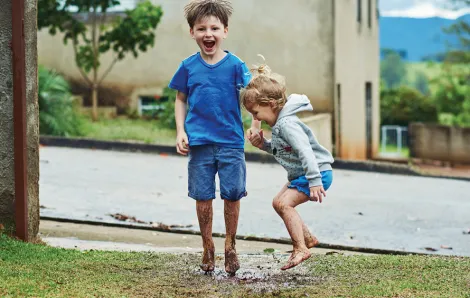 boys playing outside in a puddle
