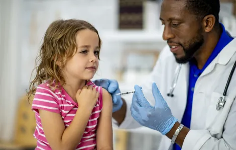 doctor giving girl a vaccination