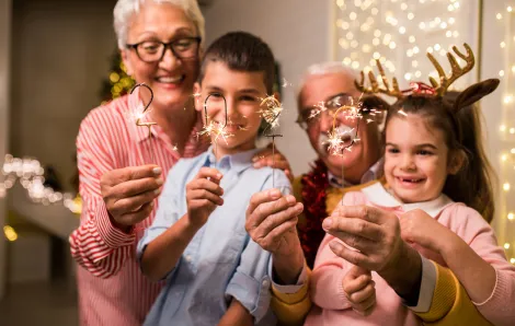 grandparents with grandchildren holding new year sparklers