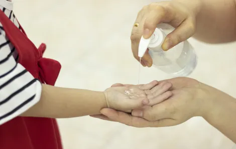 Mother and child disinfect with hand sanitizer