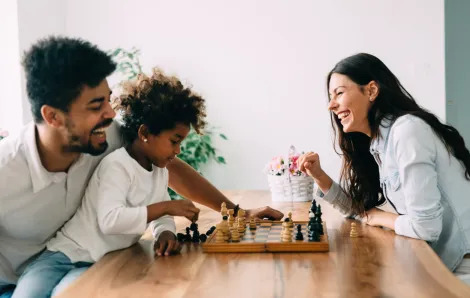family playing chess at the kitchen table