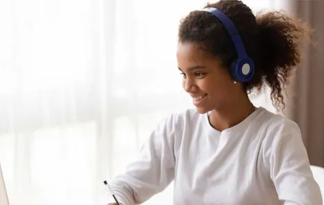 Girl on computer with headphones