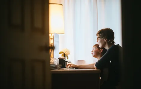 mom and son on the computer in a dark room
