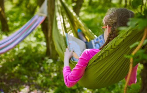 girl in hammock reading a book summer reading programs seattle-area libraries fun for kids and families