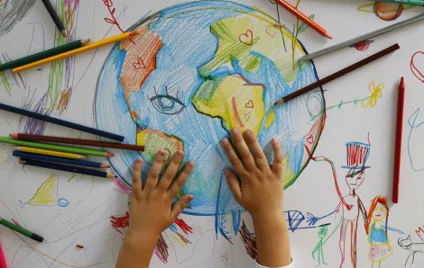 hand drawn globe with colored pencils and a kid's hands