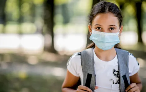 worried girl wearing a backpack and mask