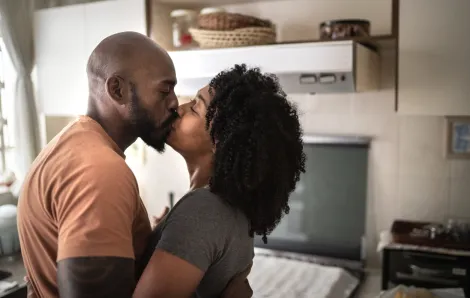 husband and wife kissing in the kitchen