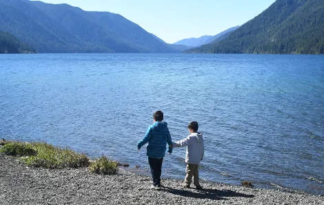 Brothers in jackets stand at the shore of Lake Crescent on Washington's Olympic Peninsula a getaway spot for Seattle-area families