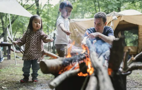 kids and a father start a fire using camping hacks that are easy for your next trip