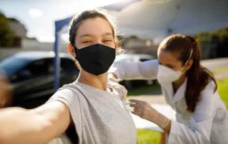 Teen girl taking a selfie while getting a vaccine