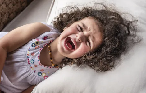 girl lying on her side screaming in a tantrum