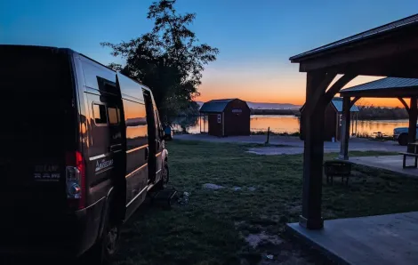 view of a camper van overlooking a sunset by a lake