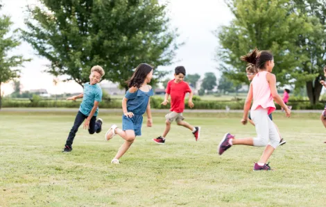 kids running in a circle out in a grassy field