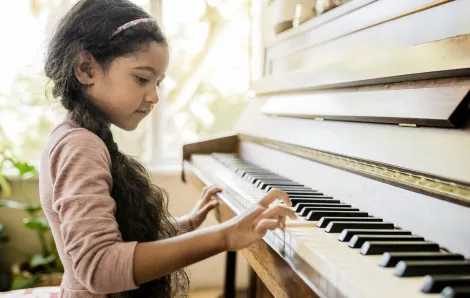 girl playing piano at home
