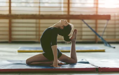 gymnast girl stretching on a mat