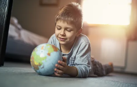 little boy looking at a globe