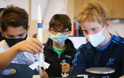 Three sixth-grade students work together on a science project