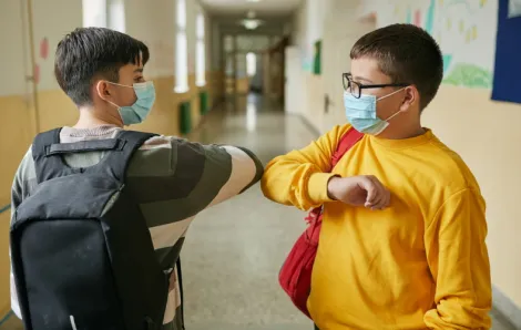 elementary student using a elbow bump as a alternative handshake during COVID-19