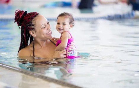Woman holding a baby in a pool at a Seattle swimming lesson
