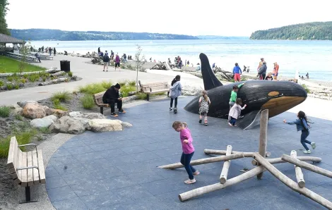 Kids play on the orca whale sculpture at Tacoma's recently reopened Owen Beach in Point Defiance Park