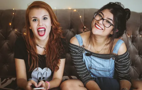 Teenagers sitting on a couch smiling
