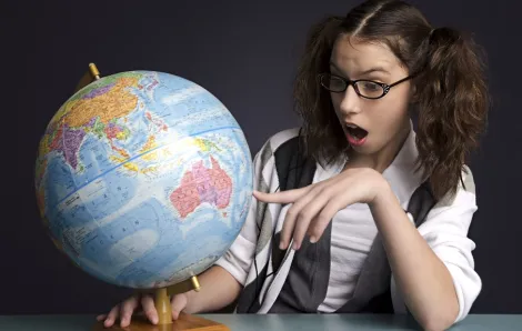 Teenage girl looks at a globe
