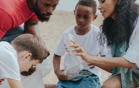 Adults and children picking p trash on a beach
