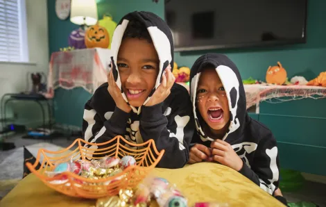 Boys-brothers-wearing-costumes-smiling-looking-at-candy-best-Halloween-weekend-events-kids-families-Seattle-Bellevue-Eastside-Tacoma-South-Sound