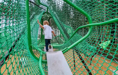 A long tube-shaped net climber is the main feature at a new playground called Hawks Landing found in the community of Tehaleh in Bonney Lake, near Seattle, Wash.