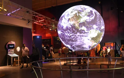 Kids look at science exhibits at Seattle's reopened Pacific Science Center among indoor play spaces for families during poor air quality