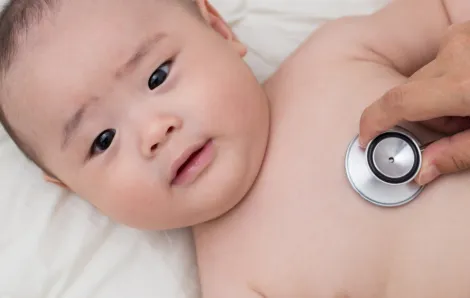 Baby lyng down with stethoscope on chest