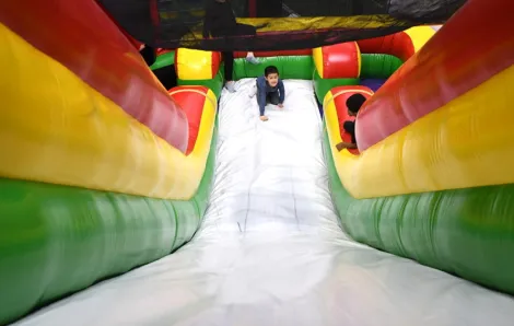 Young boy at the bottom of the Inflatable Fun Zone slide at the Issaquah Family Entertainment Center