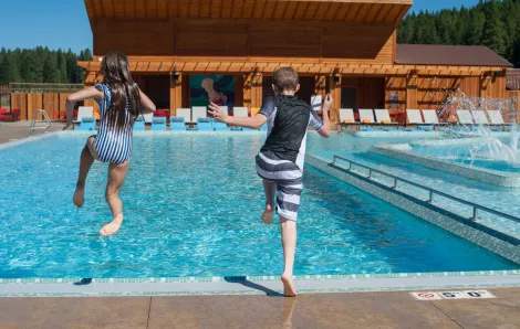 Kids jumping into the Nelson Dairy Farm swimming pool at Suncadia Resort, a family vacation destination near Seattle