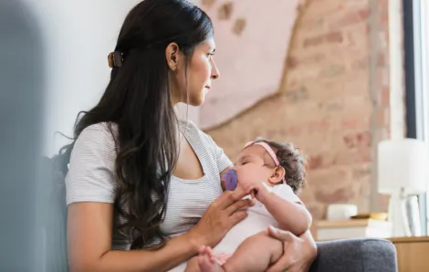 New mom looking away from baby and looking sad