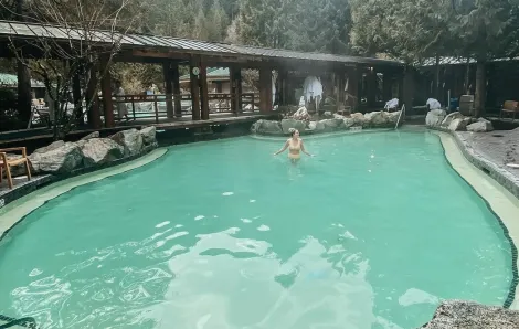 Woman in swimsuit stands in a hot springs pool at Harrison Hot Springs Resort in British Columbia, a getaway destination for Seattle area families