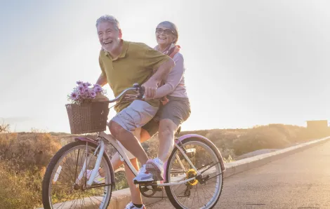 Grandparents ride a bike on a sunny day