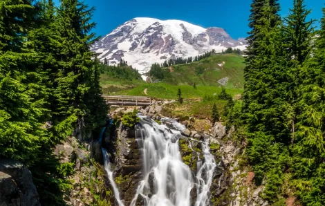 Myrtle Falls at Mount Rainier National Park, the waterfall is in the foreground, the mountain is visible in the distance and trees are on both sides