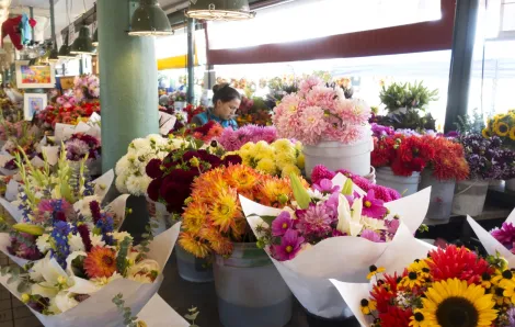 A Pike Place Market flower vendor stands behind her gorgeous colorful bouquets during the Pike Place Market Flower Festival held Mother's Day weekend in Seattle
