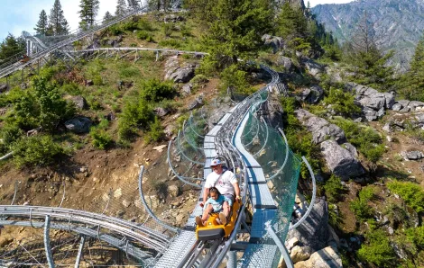 A dad and child ride a coaster car down the side of a mountain at the newly opened Leavenworth Adventure Park