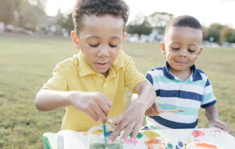 Two young boys painting outside is an easy summer activity for kids to do