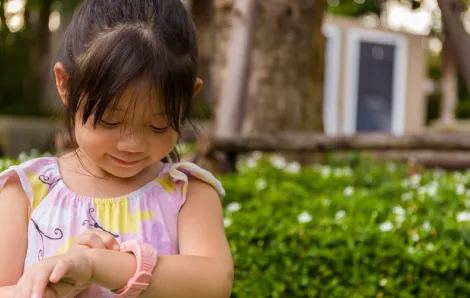 Young girl looking at her smartwatch for kids