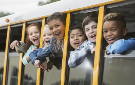Group of elementary school kids riding the bus to school